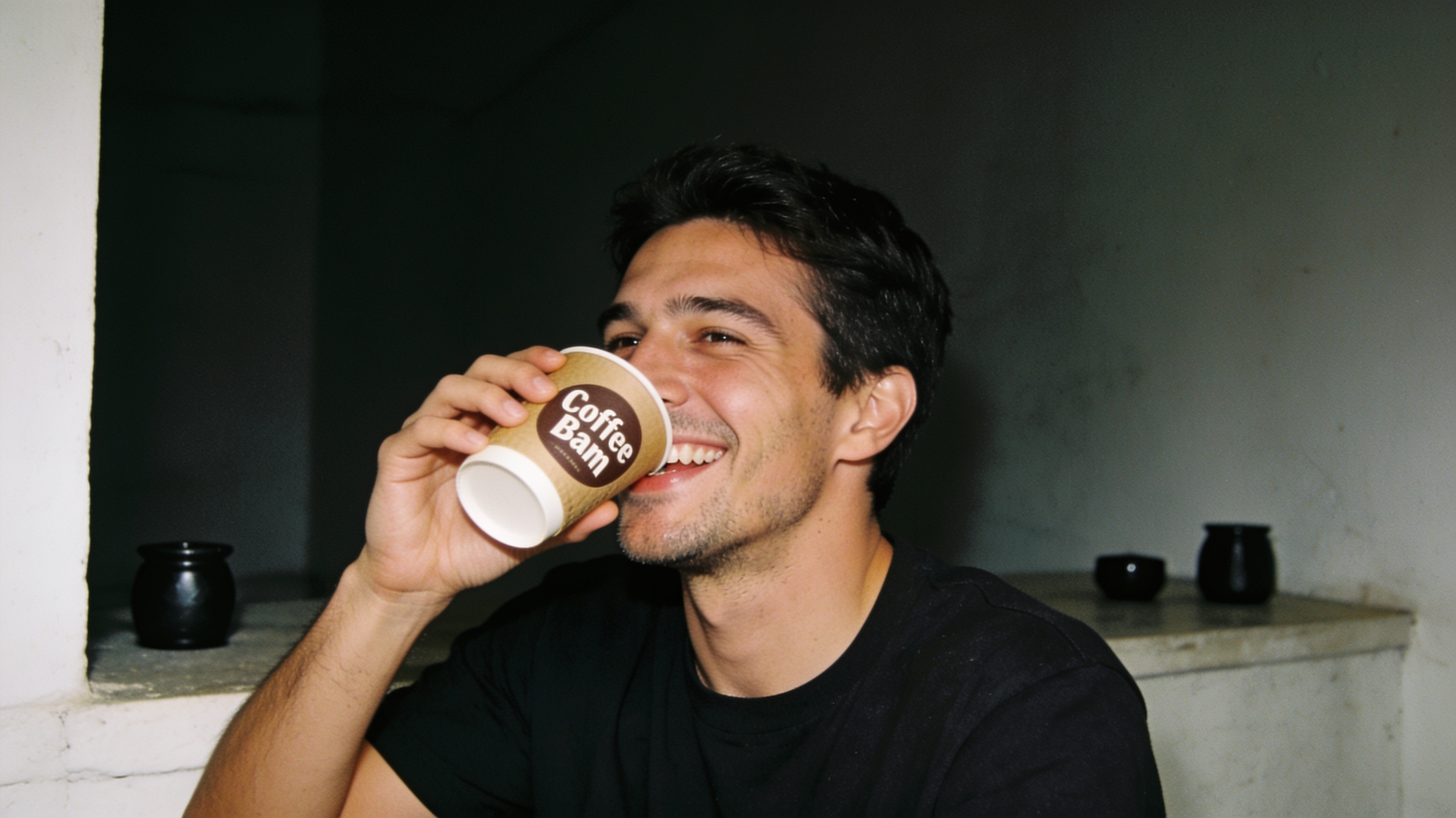 Cafe owner smiling behind an espresso bar with latte art in the foreground