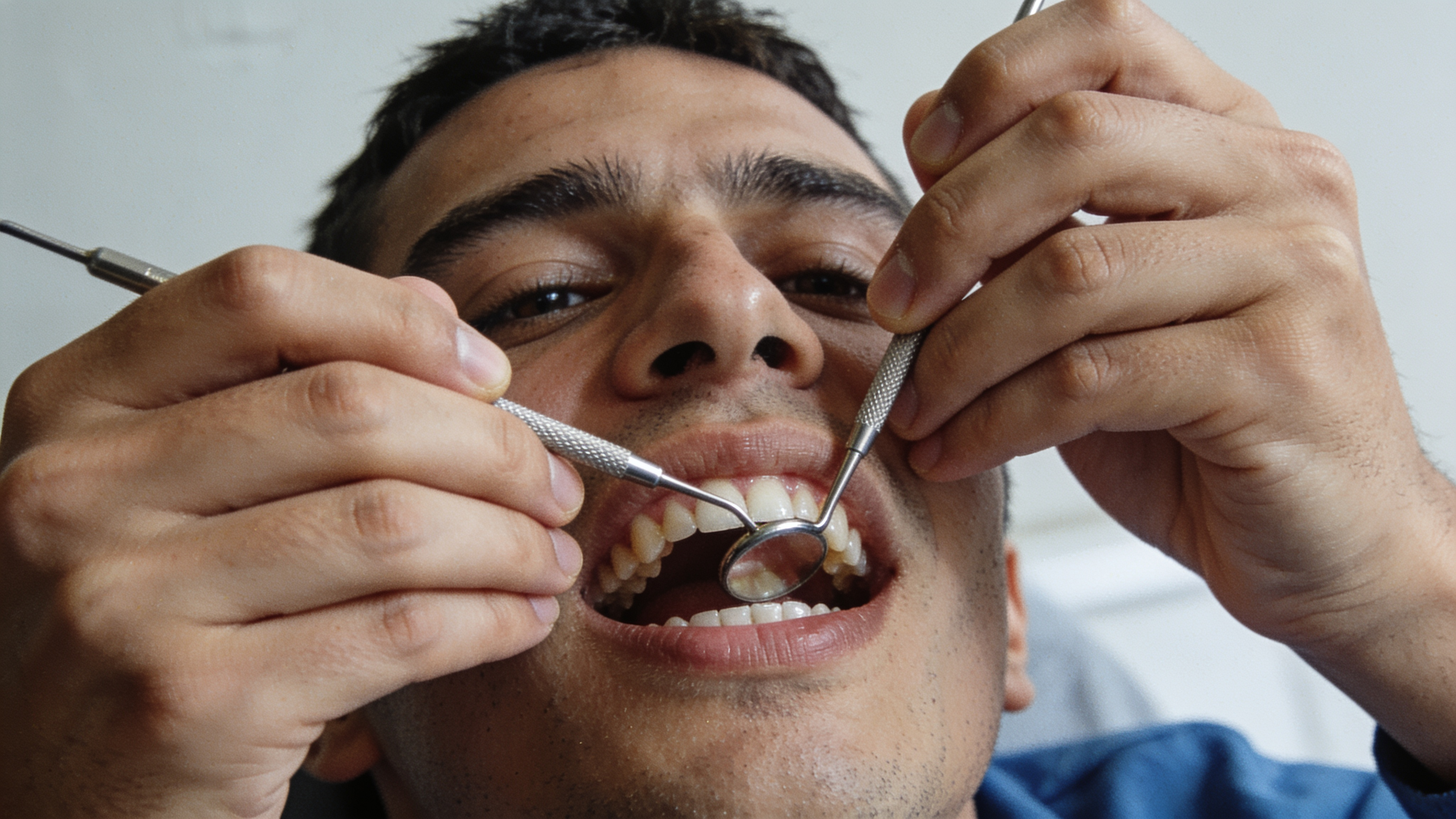 A dental hygienist smiling at a young patient during a routine cleaning appointment